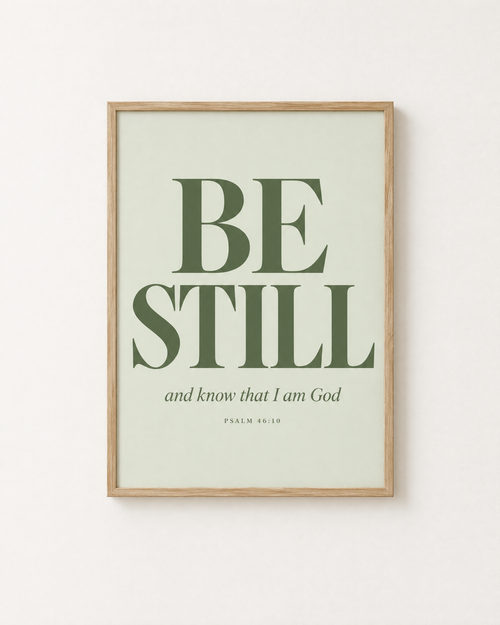 Be Still: Sage print in an oak frame on a white wall, reading “Be still, and know that I am God” (Psalm 46:10, KJV). Digital mockup.