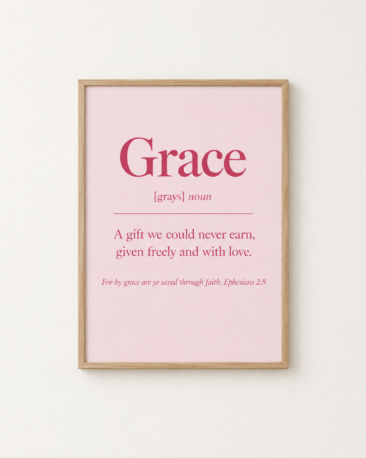 Grace: Blush print in an oak frame on a white wall, reading “For by grace are ye saved through faith” (Ephesians 2:8, KJV). Digital mockup.