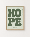 Hope: Sage print in an oak frame on a white wall, reading “The God of hope” (Romans 15:13, KJV). Digital mockup.