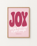 Joy: Blush print in an oak frame on a white wall, reading “The joy of the LORD is your strength” (Nehemiah 8:10, KJV). Digital mockup.