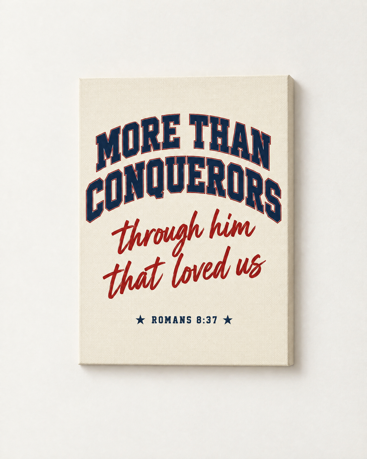 More Than Conquerors: Varsity print as a gallery-wrapped canvas on a white wall, reading “More than conquerors through him that loved us” (Romans 8:37, KJV). Digital mockup.