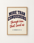 More Than Conquerors: Varsity print in an oak frame on a white wall, reading “More than conquerors through him that loved us” (Romans 8:37, KJV). Digital mockup.