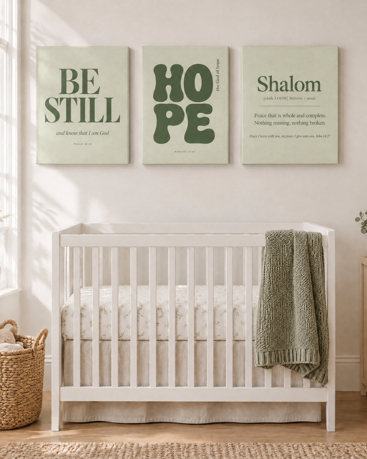 Digital mockup: the Sage Set of 3 as gallery-wrapped canvases above a crib: BE STILL “and know that I am God” (Psalm 46:10), HOPE “the God of hope” (Romans 15:13) and Shalom (John 14:27).
