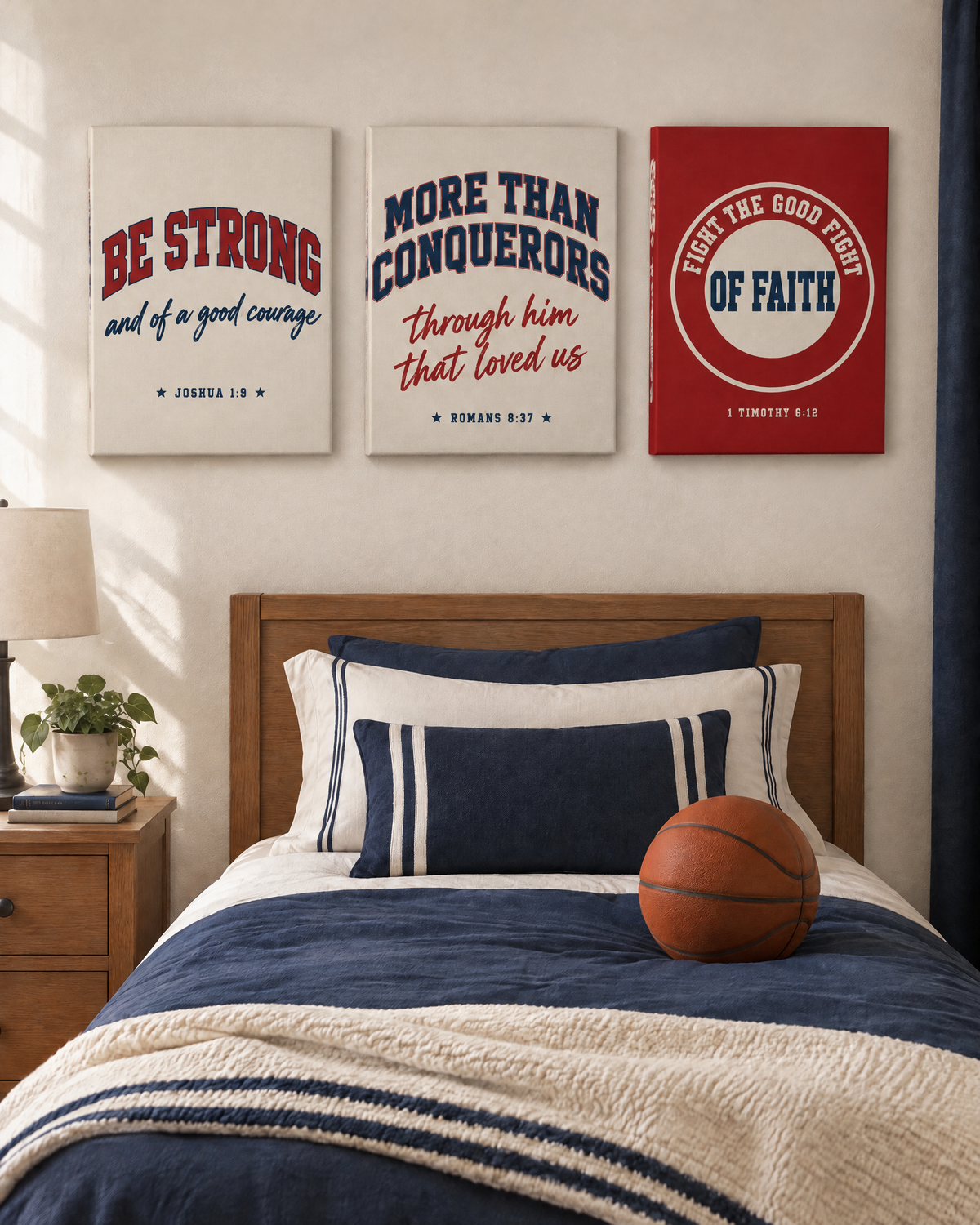 Digital mockup: the Varsity Set of 3 as gallery-wrapped canvases above a twin bed: BE STRONG “and of a good courage” (Joshua 1:9), “More than conquerors through him that loved us” (Romans 8:37) and “Fight the good fight of faith” (1 Timothy 6:12).